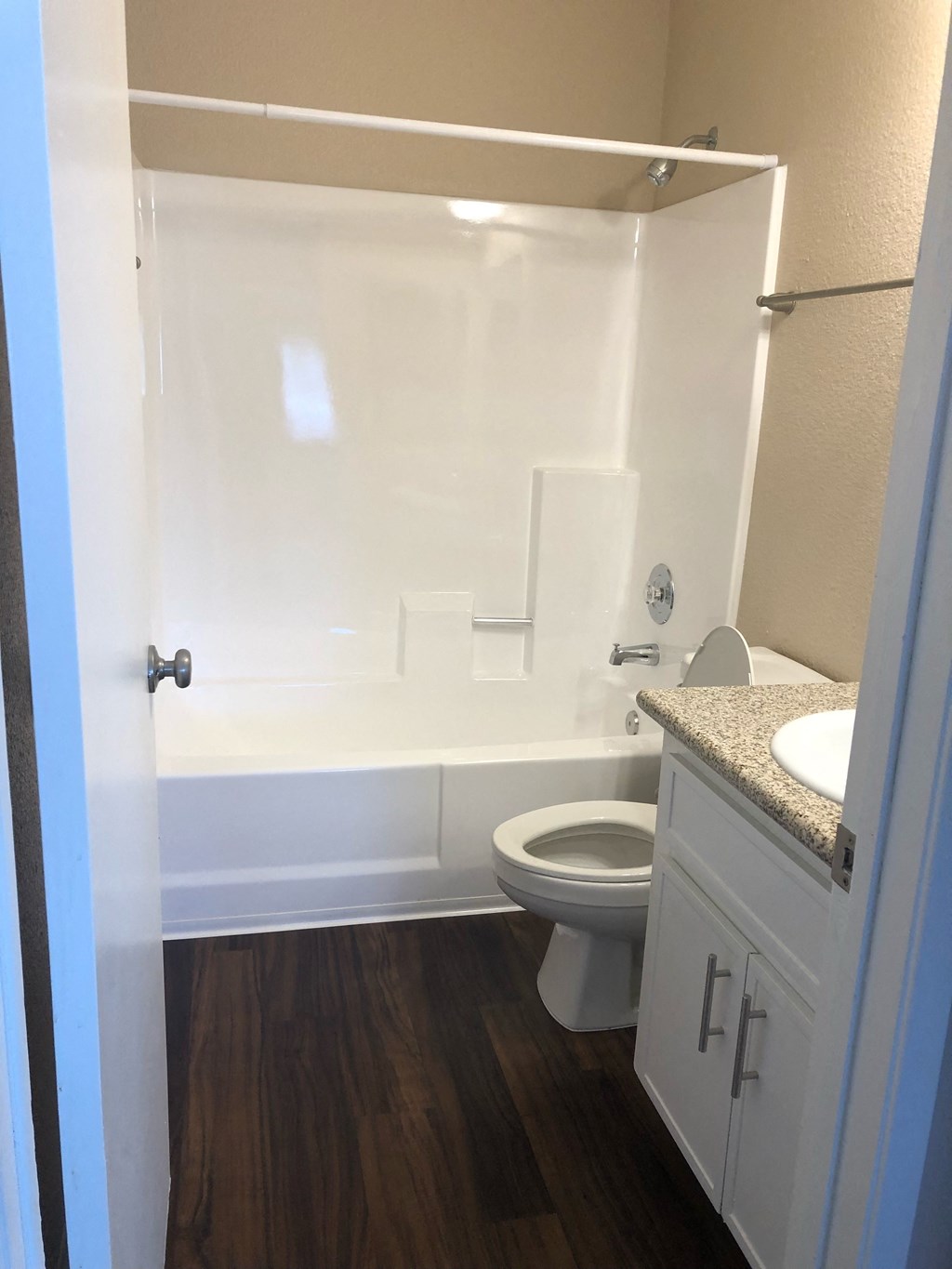 Full bathroom with granite counter top and brushed nickel fixtures at Grande Vista Apartments.
