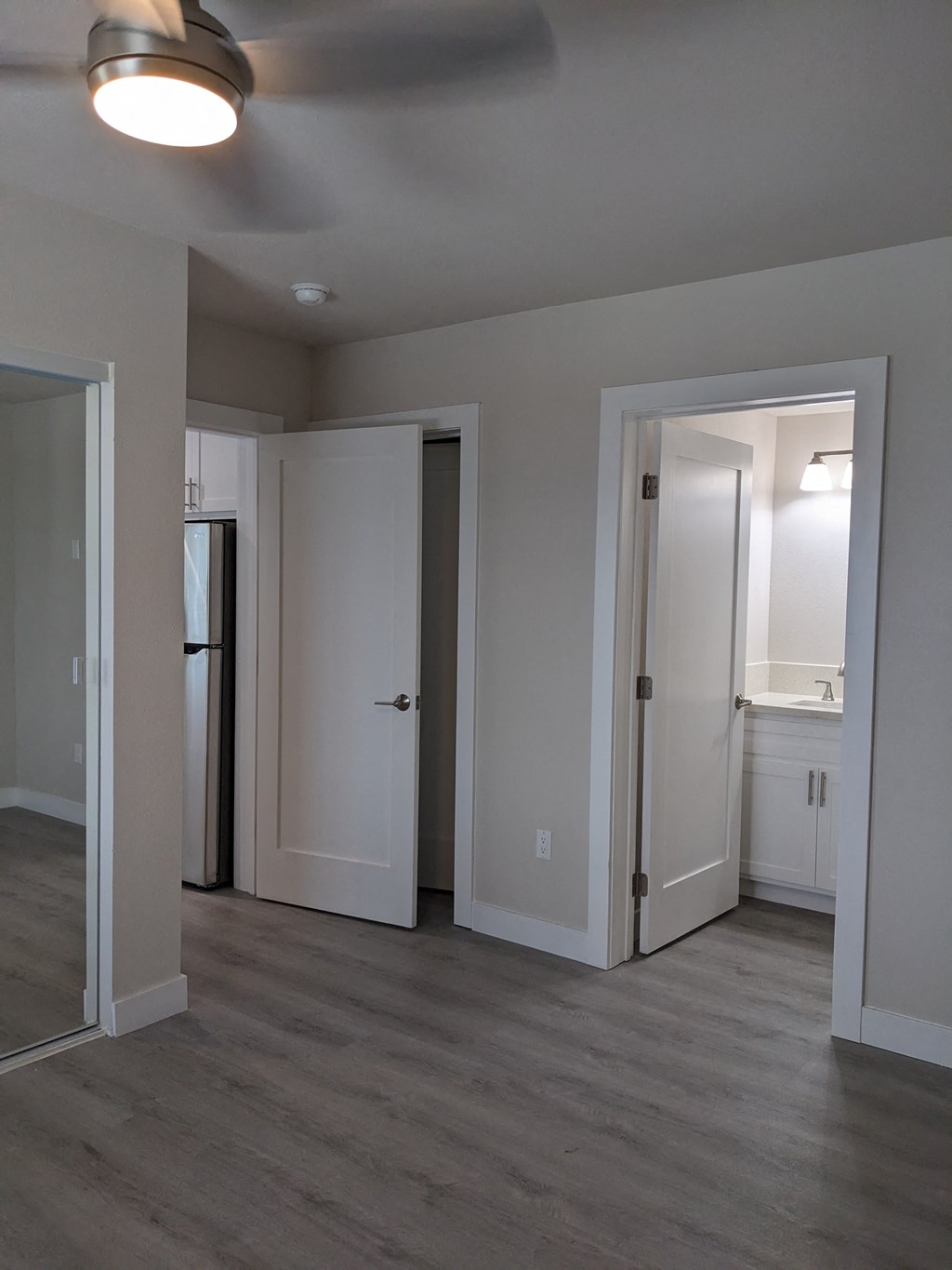 Ensuite bedroom with mirrored closet doors adjacent to the kitchen at The Hardison Apartments in Pasadena, California.