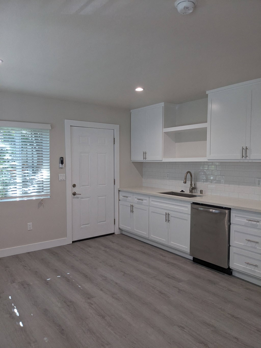 Spacious kitchen with lots of natural light and white cabinets at The Hardison Apartments in Pasadena, California.