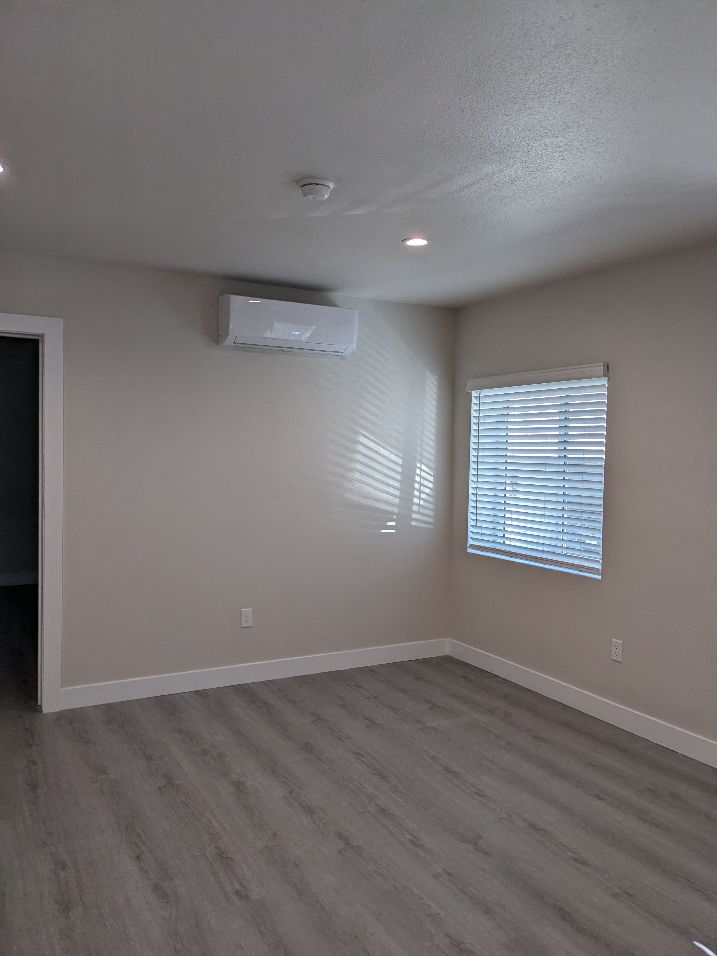 Bedroom with lots of natural light and air conditioning at The Hardison Apartments in Pasadena, California.
