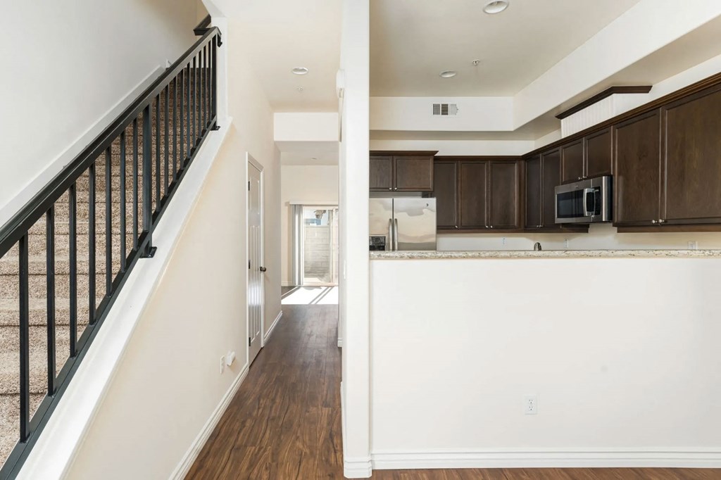 Front entrance view of kitchen and hallway to living room and sliding glass doors to private porch at The Nines Townhomes in Escondido, California.