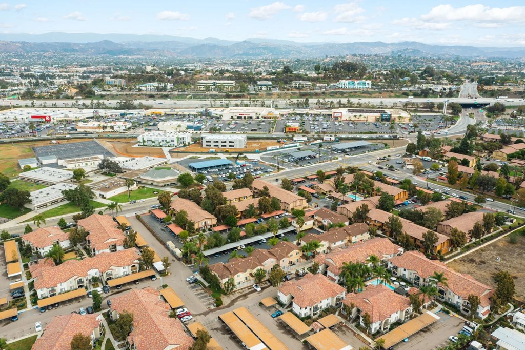 Aerial view of neighborhoods and shopping centers around The Nines Townhomes in Escondido, California.
