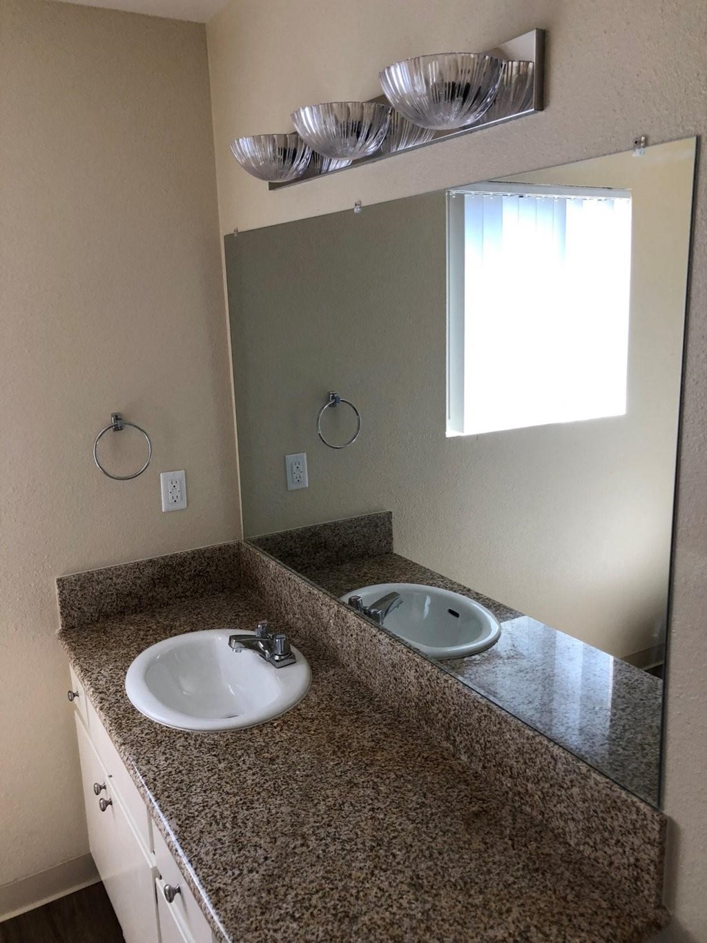 Bathroom with large vanity and great natural lighting at Plaza Verde Apartments in Escondido, California.