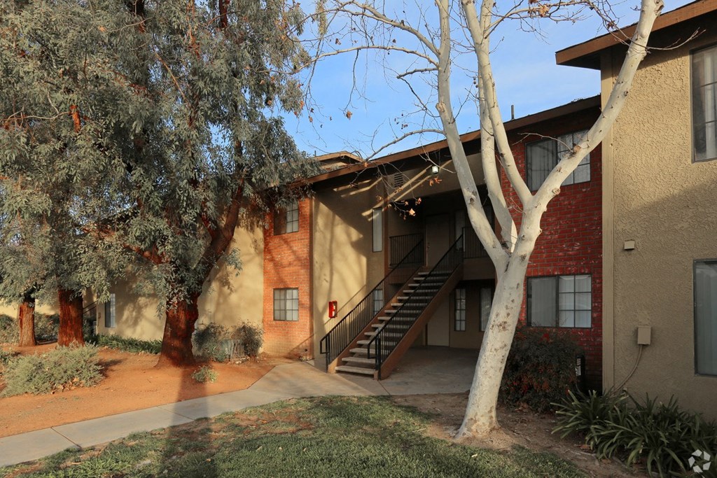 Mature trees around one of the two story units at Riverdale Apartment Homes in Hemet, California.