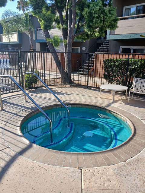 A small round pool with a metal fence around it.