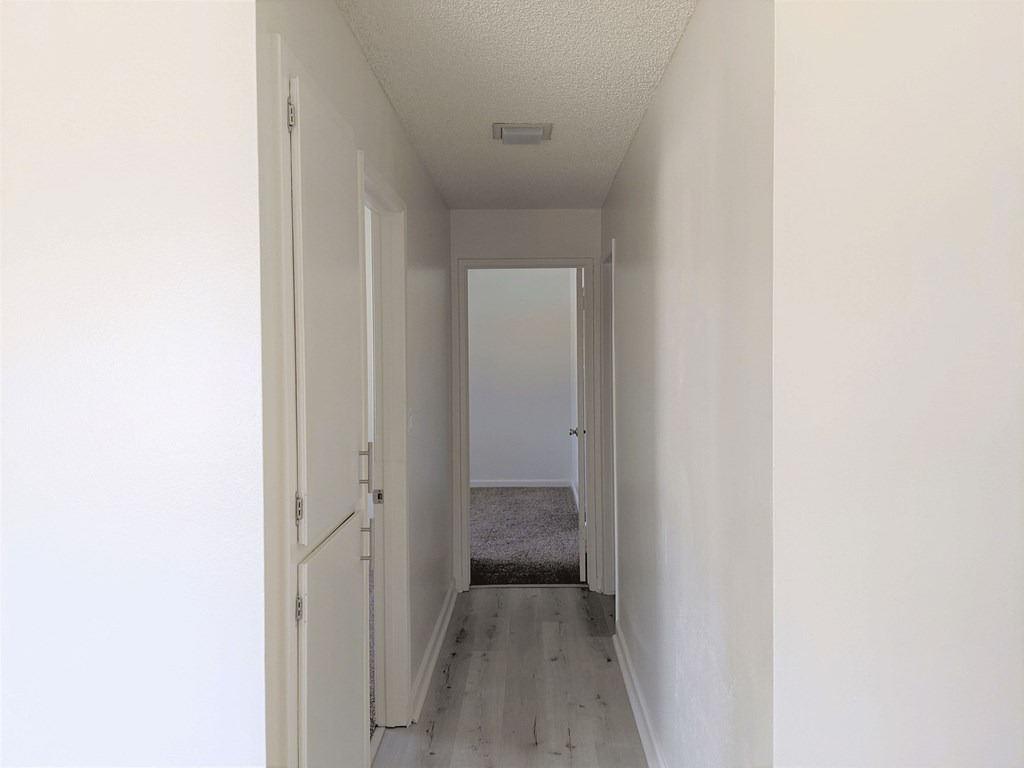 Hallway to bathroom and bedroom with storage cabinets in apartment unit at the Steckel Apartments in Santa Paula, California.