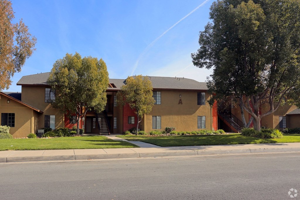 Street view of well kept landscapting at Riverdale Apartment Homes in Hemet, California.