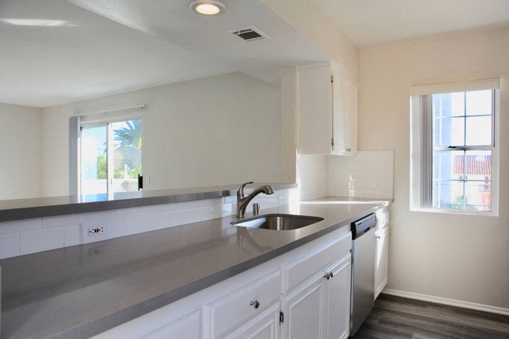 Open kitchen with lots of white cabinets in unit at Summer House Apartments in Ventura, California.