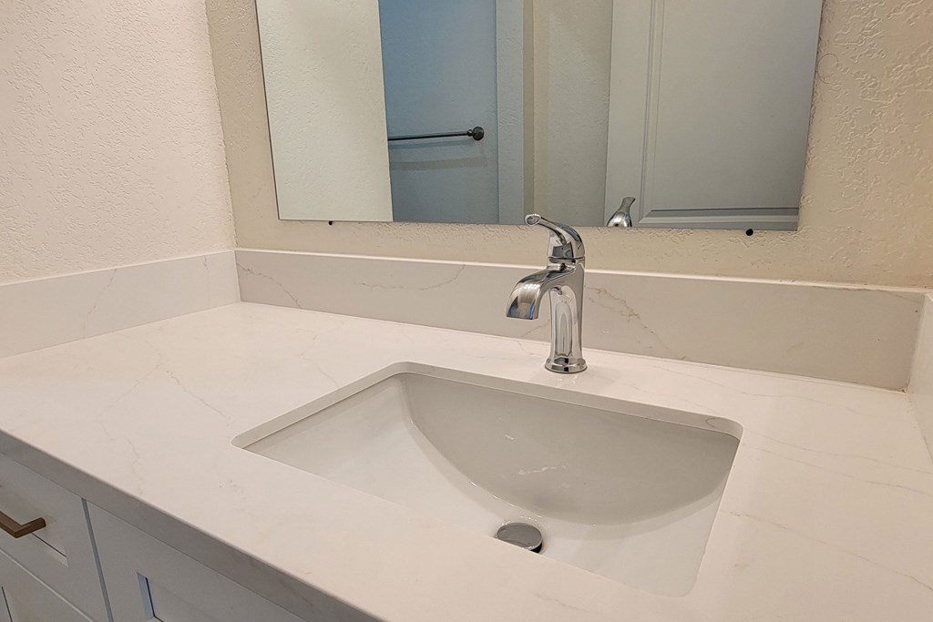 Bathroom sink and white cabinets in unit 17 at The Willows at Washington apartments in El Cajon, California.