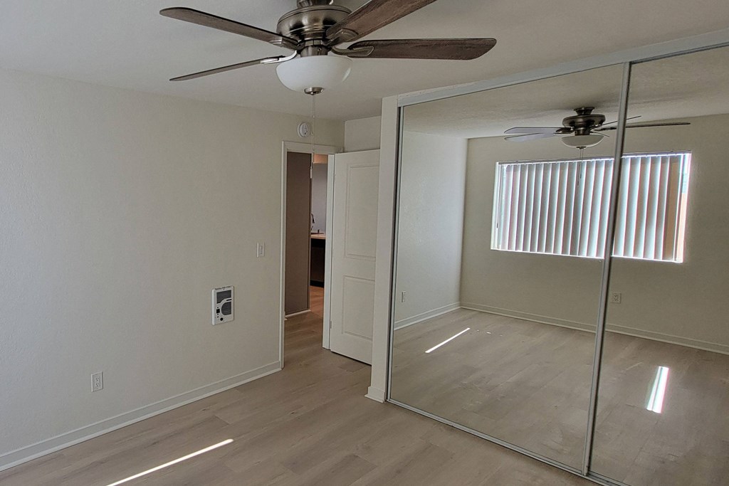 Bedroom two with large closets and window in unit 21 at The Willows at Washington apartments in El Cajon, California.