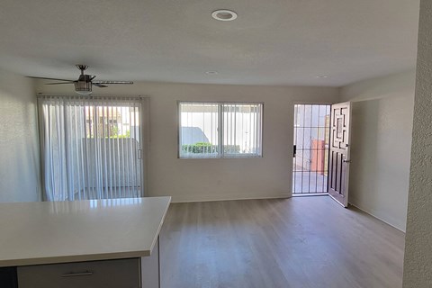 an empty living room with sliding glass doors to a balcony