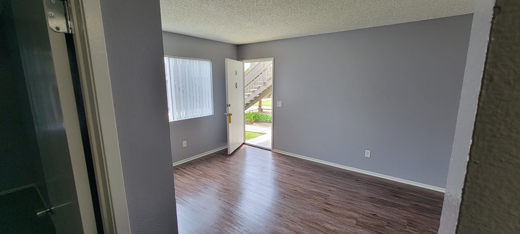 Front room with hardwood floors and lots of natural light at Grand Oaks Apartments in Lake Elsinore, California.
