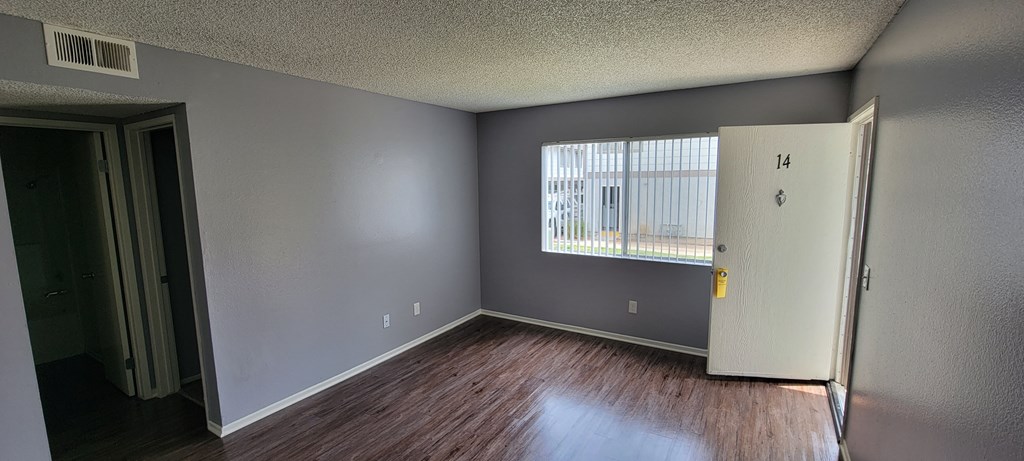 Front room with hardwood flooring and lots of natural light at Grand Oaks Apartments in Lake Elsinore, California.