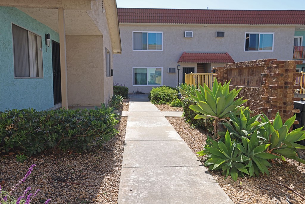 Walkway between buildings behind BBQ area at The Willows at Washington in El Cajon, California.