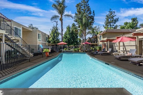 A swimming pool surrounded by a fence and trees.