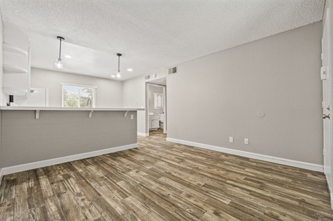 A room with wooden flooring and white walls.