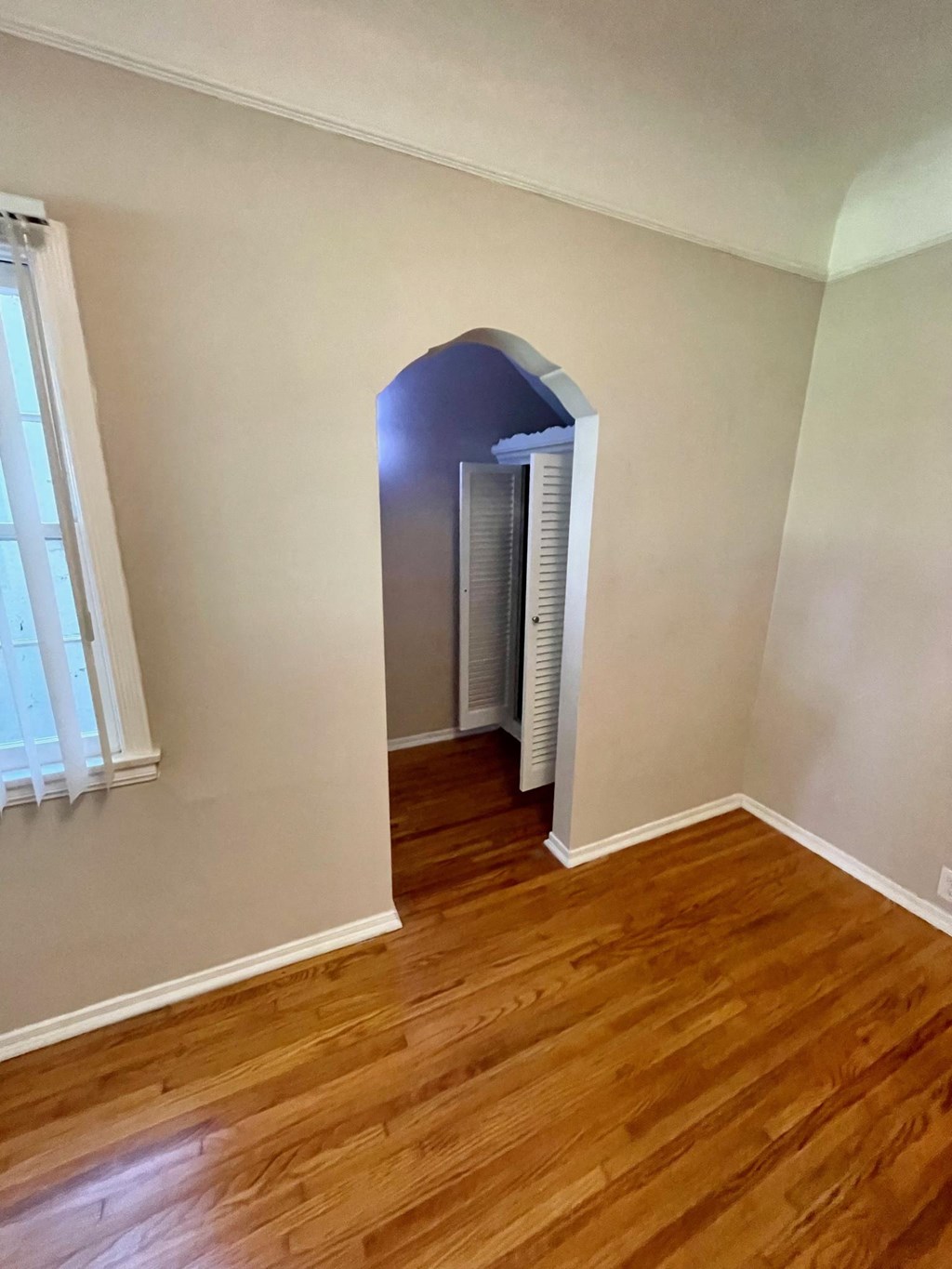 Bedroom with vintage walk-in closet and hardwood floors at Orange Grove Apartments in Pasadena, CA.
