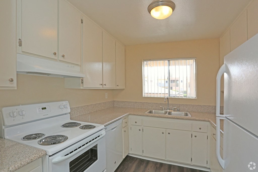 Kitchen with spacious white cabinets and white appliances at Villa Pacific Apartments in Oceanside, California.