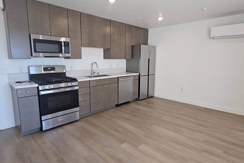 A kitchen with a stove, oven, microwave, and refrigerator.
