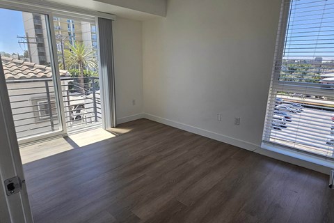 A room with a sliding glass door leading to a balcony.