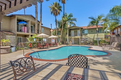 A pool surrounded by a patio and chairs.