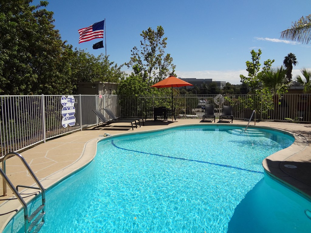 Sparkling clear swimming pool and sun deck at Villa Knolls Apartments in La Mesa, California.