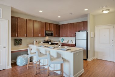 a kitchen with a large island and white chairs
