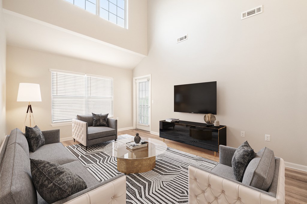 a living room with a couch and chair and a tv on the wall