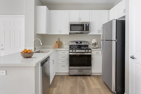 a kitchen with white cabinets and stainless steel appliances