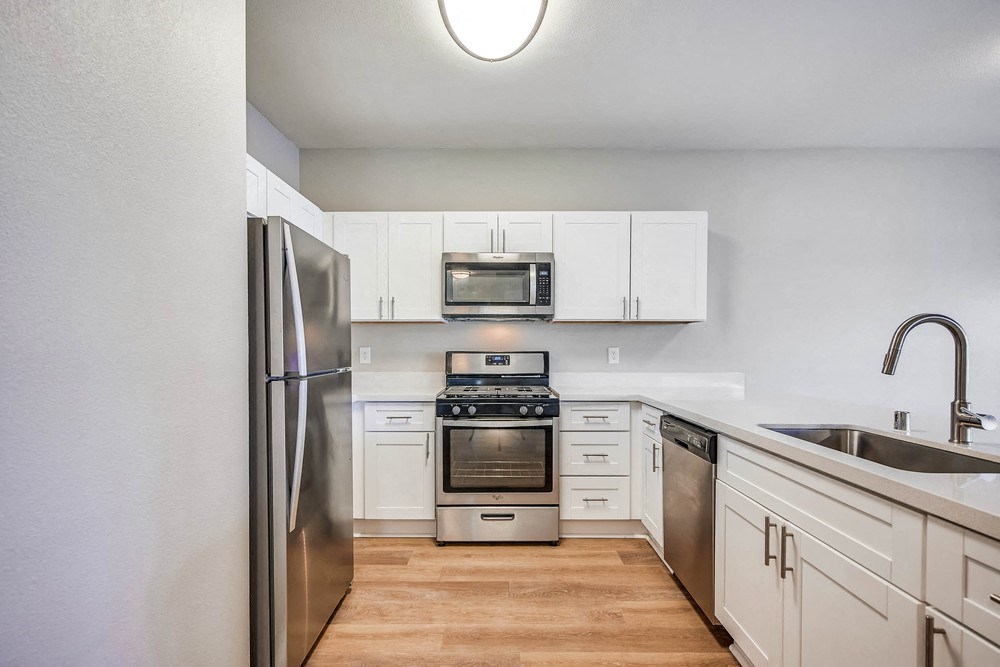 a kitchen with white cabinets and stainless steel appliances