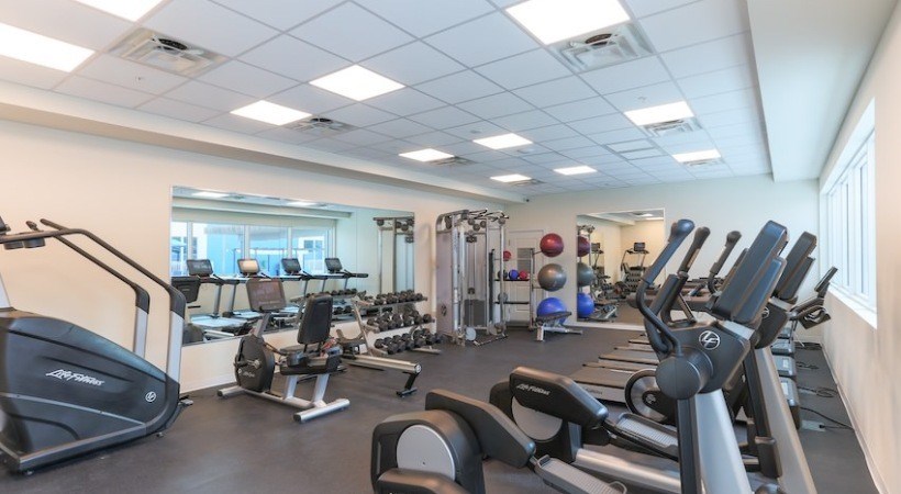 A gym with treadmills, exercise bikes, and other equipment.