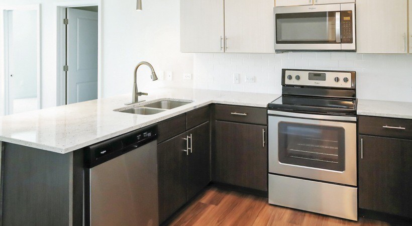 A modern kitchen with a stainless steel dishwasher and oven.