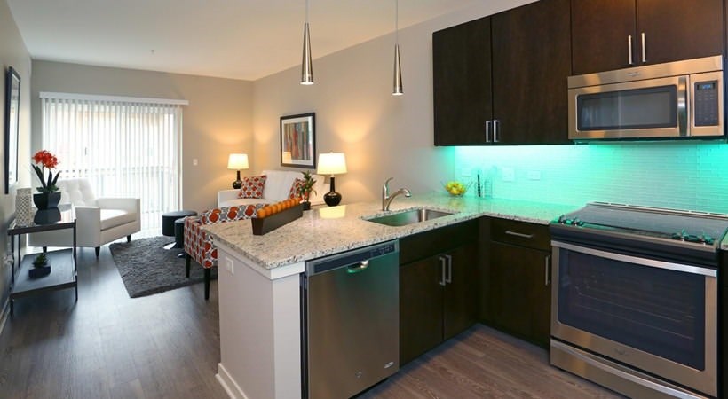 A kitchen with a refrigerator, oven, and microwave.