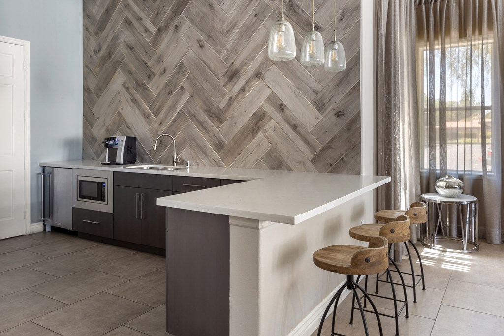 a kitchen with a white counter top and wooden stools