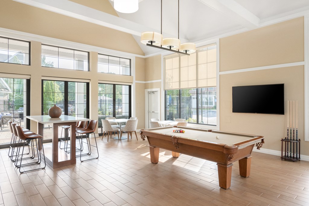 a spacious game room with a pool table and a flat screen tv
