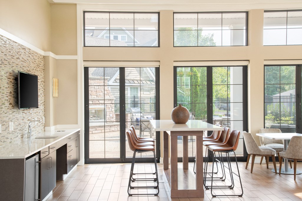 a kitchen with large windows and a table with chairs