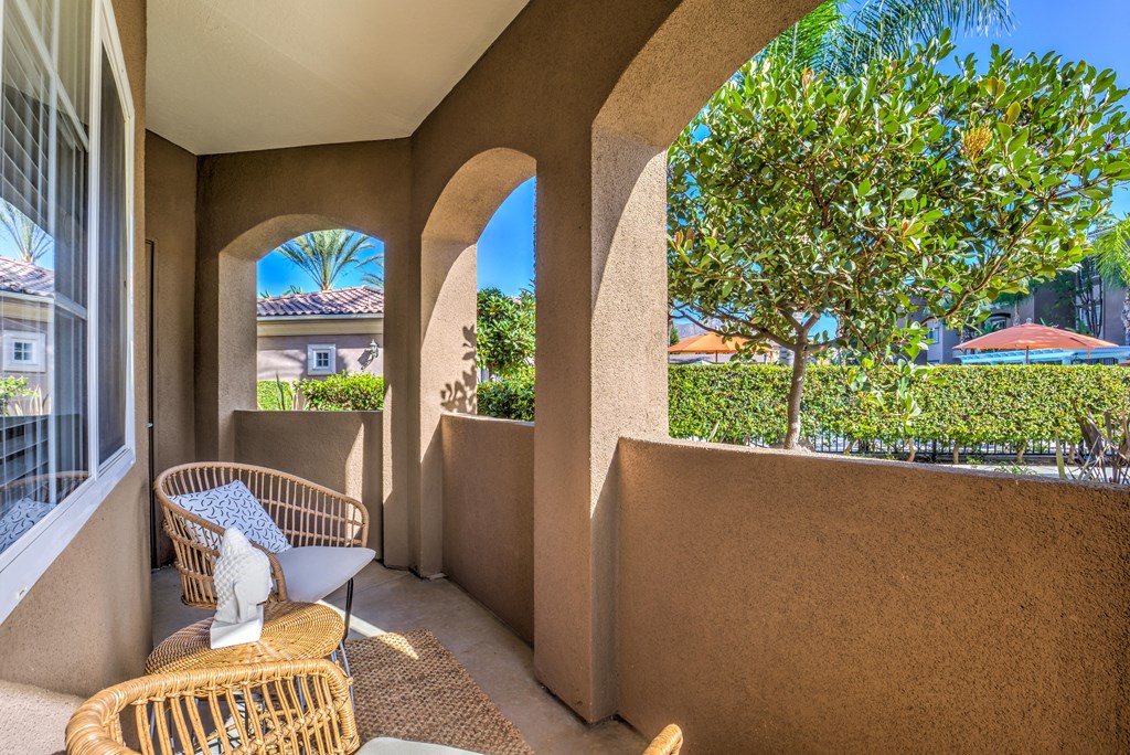 a patio with wicker chairs and a statue