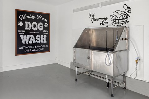 a stainless steel tub in a room with a sign on the wall that says wet noses and