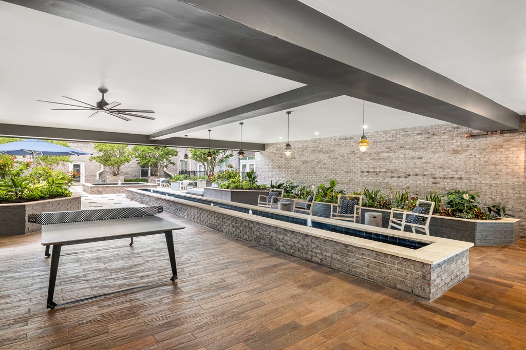 a patio with a ping pong table and a seating area