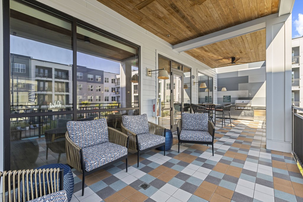 A patio with a black and white checkered floor and a wooden ceiling.