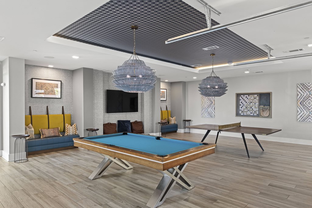 A pool table is in the middle of a room with a TV and a couch.