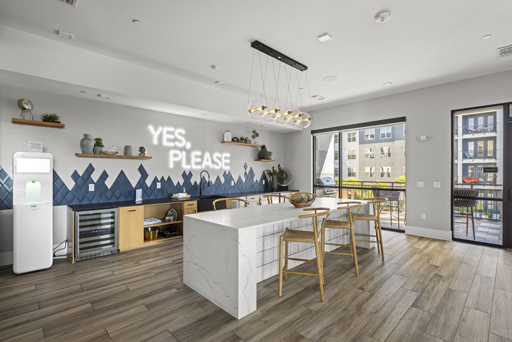 A kitchen with a white island and wooden chairs.