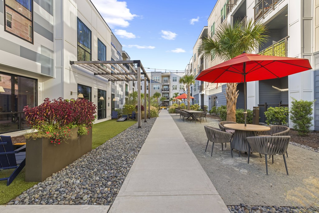 A red umbrella is on a patio table.