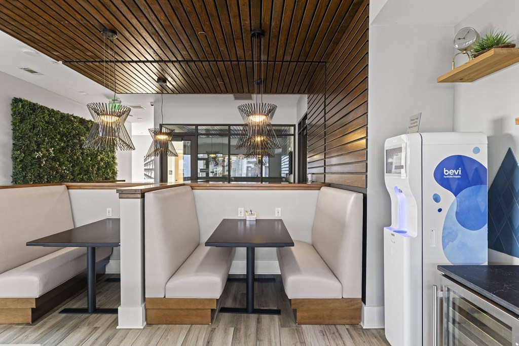 A modern dining area with a wooden ceiling and a green wall.