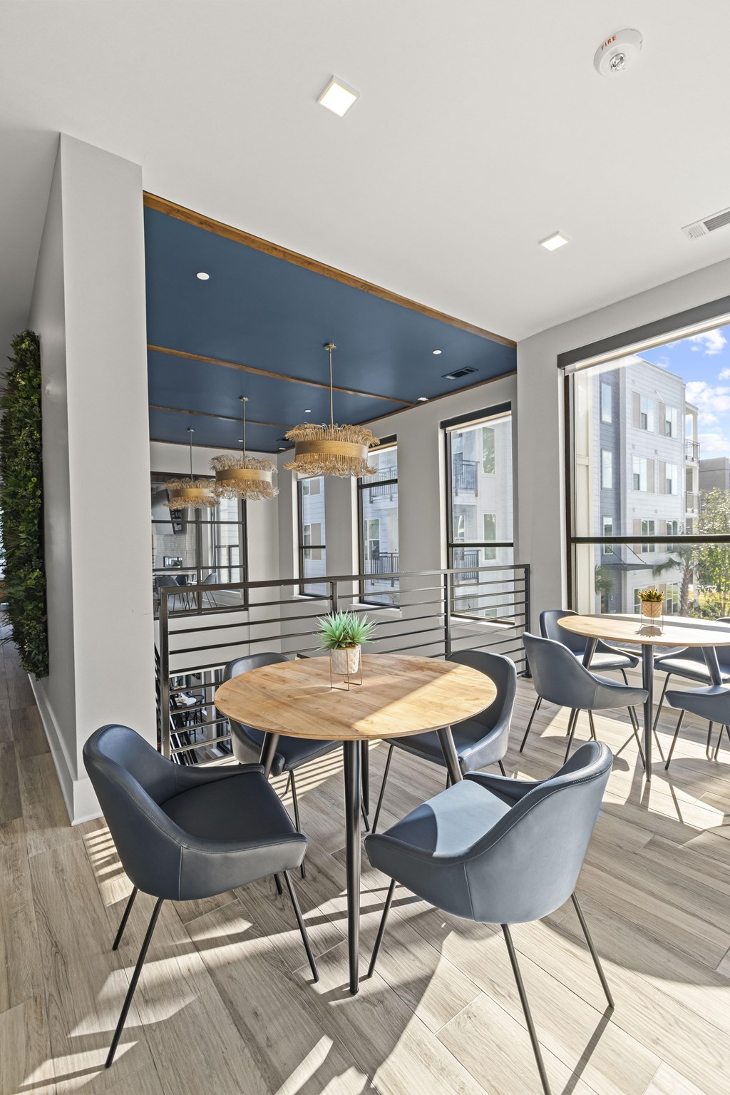 A modern dining area with a round wooden table surrounded by grey chairs.