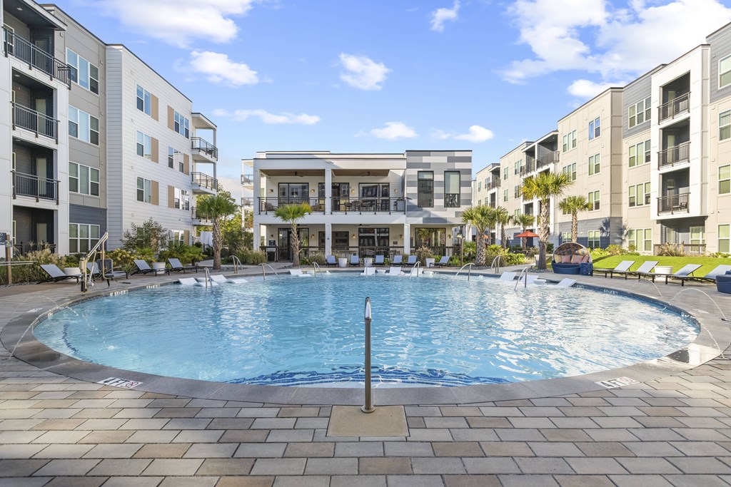 A large swimming pool in the middle of a courtyard surrounded by buildings.