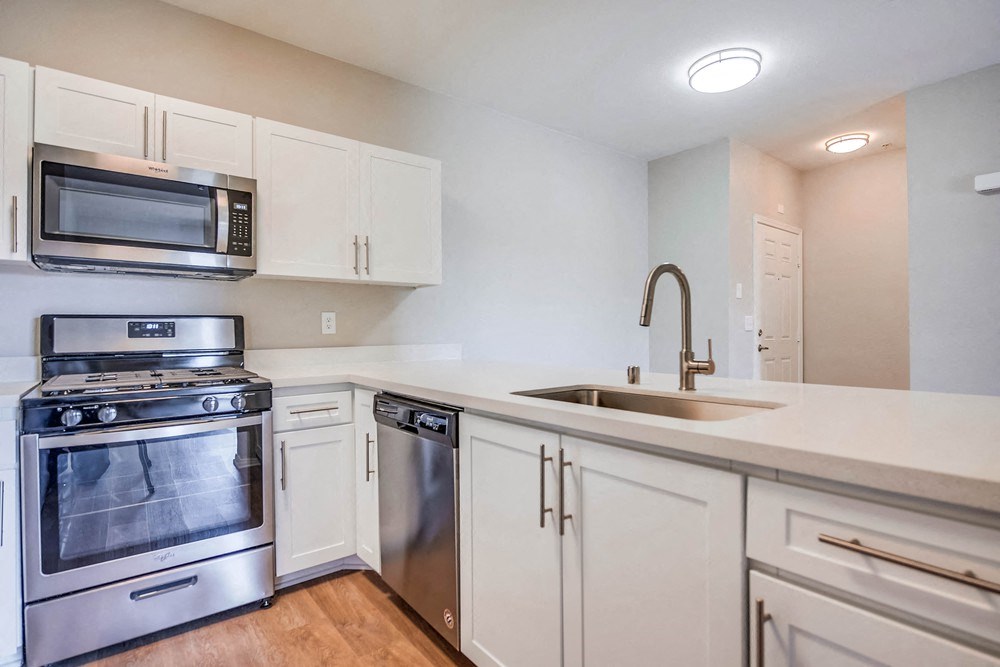 a kitchen with white cabinets and stainless steel appliances