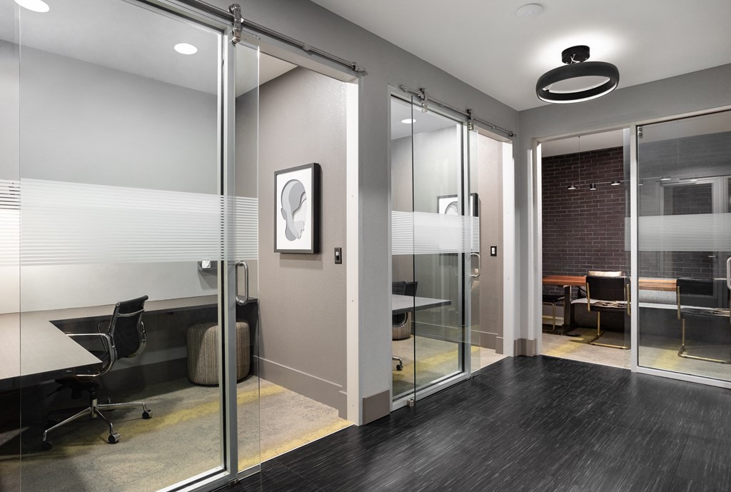 a conference room with glass sliding doors and a desk