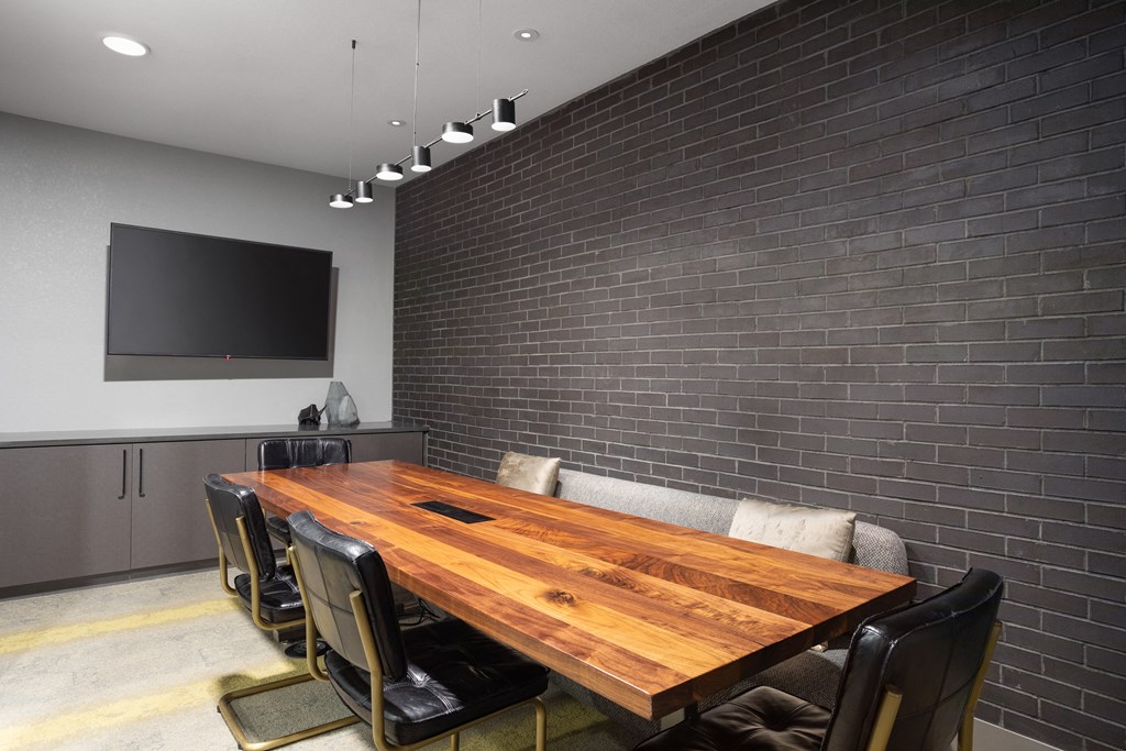 a conference room with a wooden table and chairs and a television
