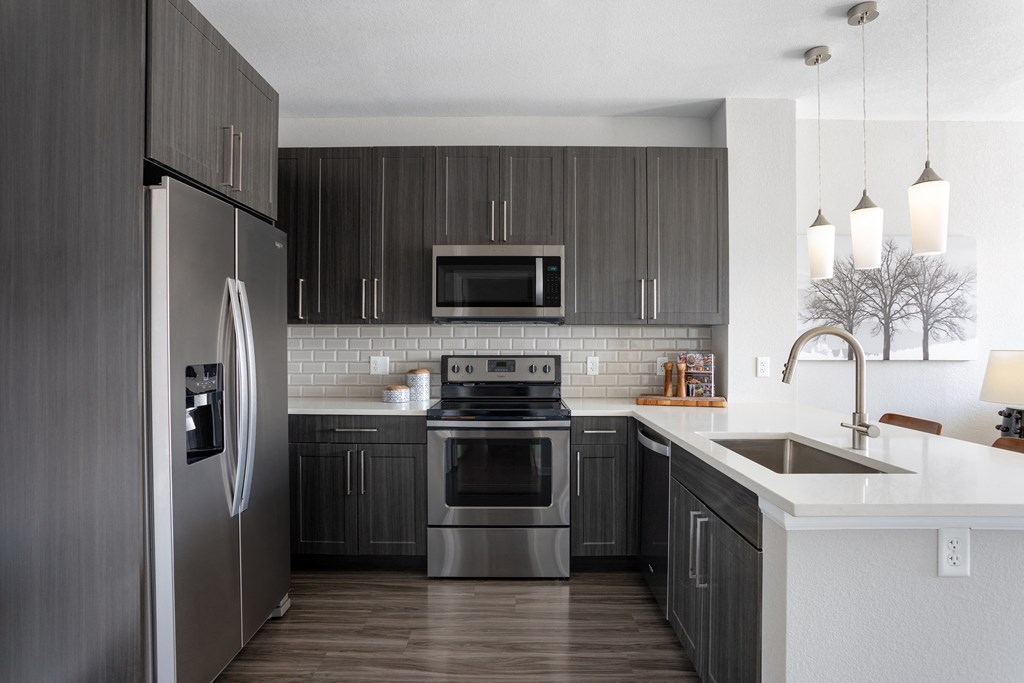 a kitchen with stainless steel appliances and white counter tops